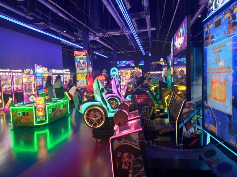 Neon-lit indoor arcade games and redemption machines inside a family entertainment center