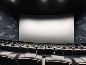 Rows of empty seats facing a large screen inside a movie theater auditorium