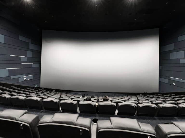 Rows of empty seats facing a large screen inside a movie theater auditorium