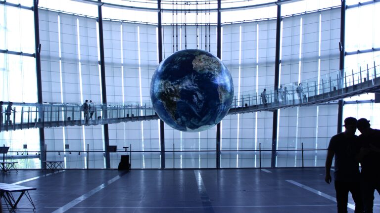 Interactive Earth globe exhibit inside a modern indoor science museum atrium